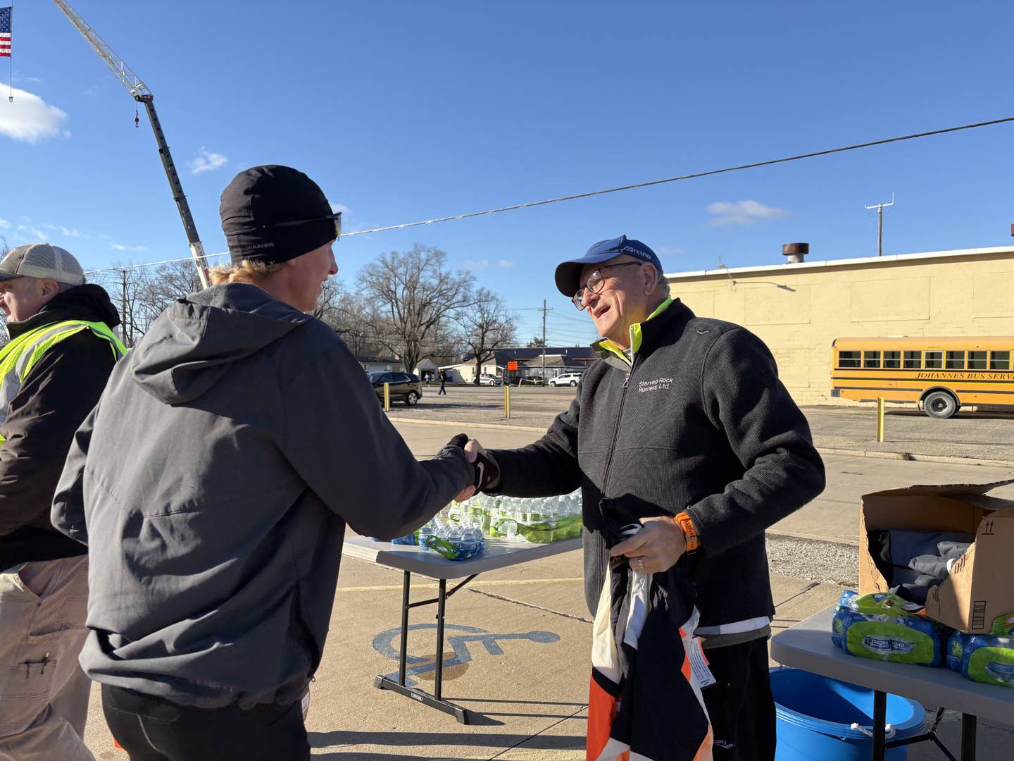 Race director Mitchell Hobbs shakes hands with Blake Oleson after Oleson took home first place at Thursday’s Oglesby Turkey Trot.