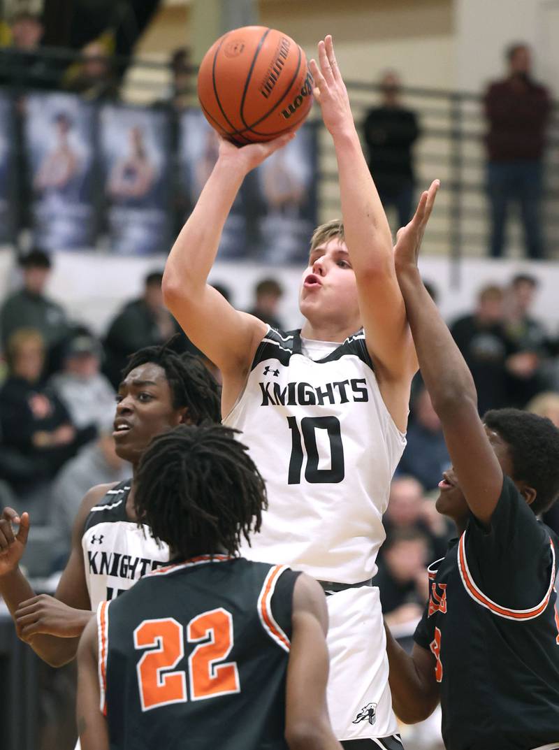 Kaneland's Troyer Carlson shoots a jump shot between two DeKalb defenders during their game Tuesday, Jan. 24, 2023, at Kaneland High School.