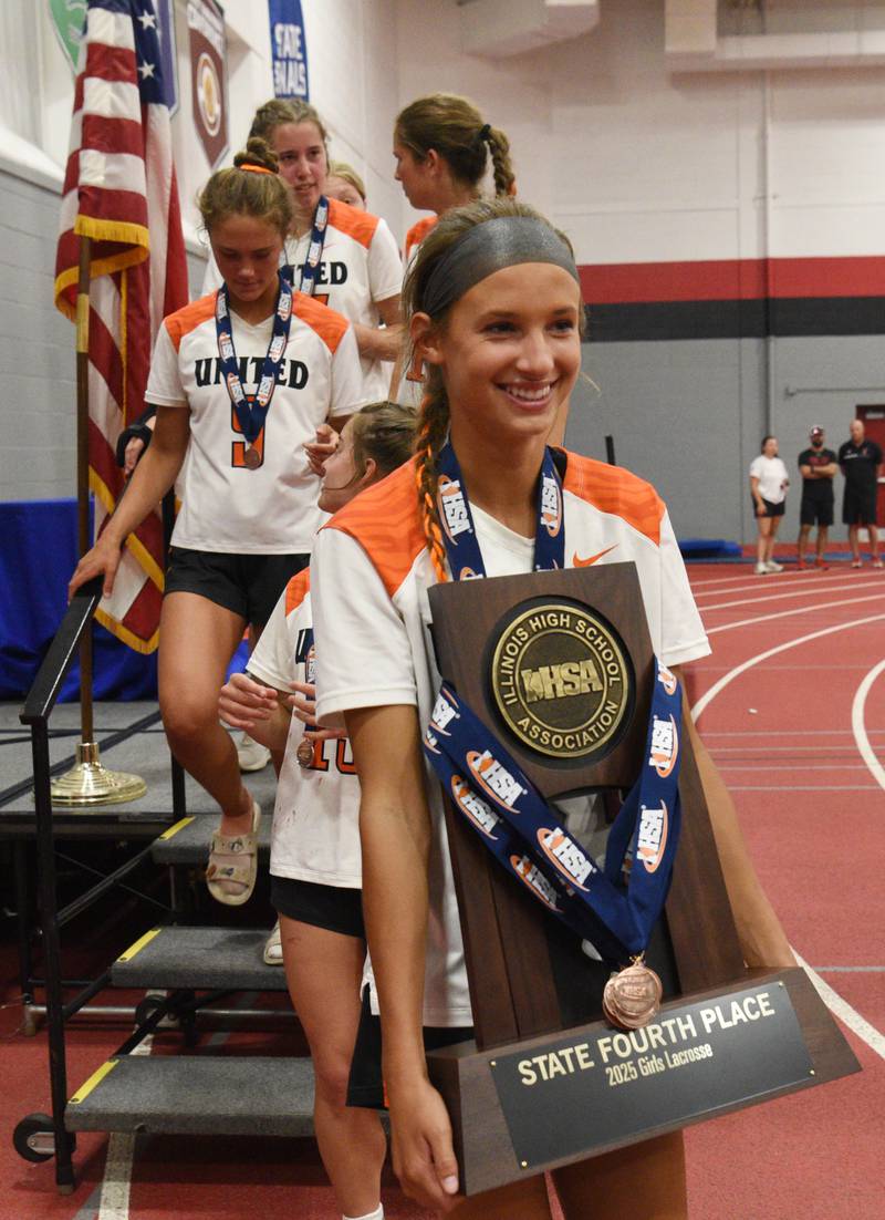 Crystal Lake Central Coop’s Addie Bechler carries the team’s fourth-place trophy after the girls lacrosse state finals at Hinsdale Central High School on Saturday, June 7, 2025.