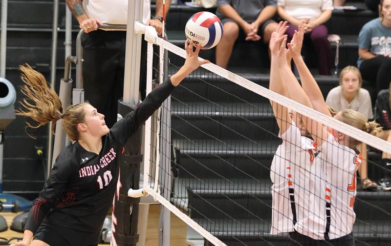 Indian Creek's Audrey Witte tries to tip the ball past two DeKalb blockers during their match Tuesday, Sept. 6, 2022, at Indian Creek High School in Shabbona.