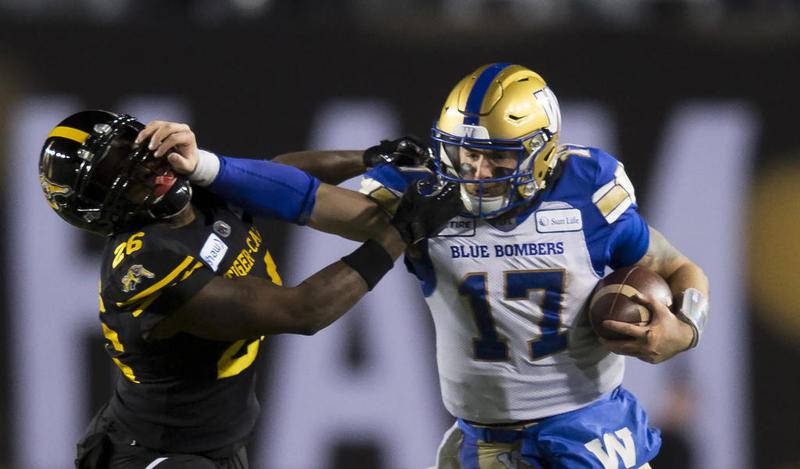 Winnipeg Blue Bombers quarterback Chris Streveler, a Marian Central graduate from Crystal Lake, stiff-arms the Hamilton Tiger-Cats' Cariel Brooks in the second half of the 107th Grey Cup on Sunday in Calgary, Alberta.