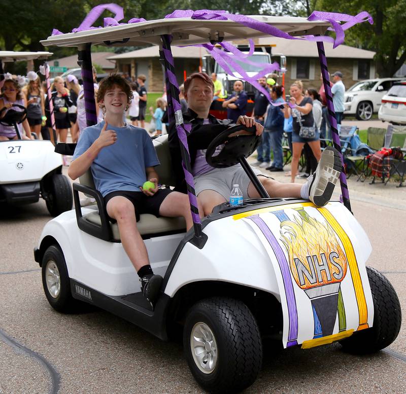 Sophomore Luke Pawlak (left) and senior Tommy Whitney (right) drive the Kaneland High School National Honor Society golf cart in the 2024 Kaneland Homecoming Parade in Sugar Grove on Wednesday, Oct. 4, 2024.