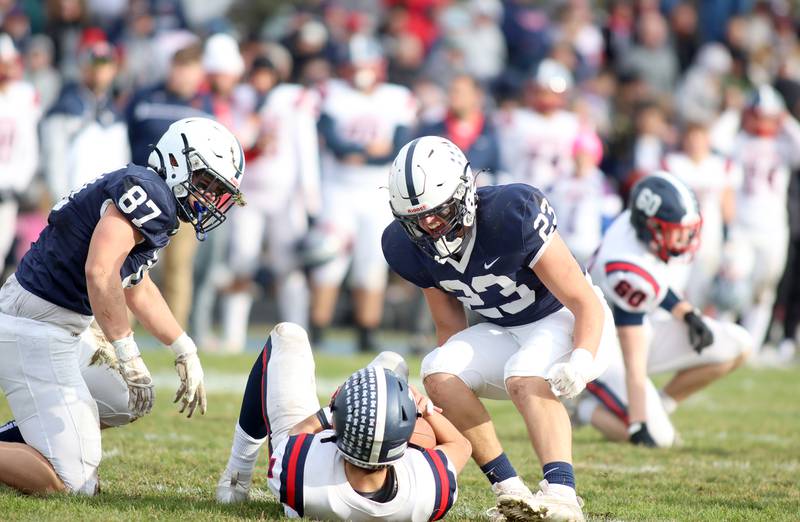 Cary-Grove’s Jake Cody, left, and Paul Brock loom over  Belvidere North’s quarterback Nicolas Tapia following a sack in IHSA Class 6A quarterfinal playoff football action on Saturday, Nov. 16, 2024, at Al Bohrer Field on the campus of Cary-Grove High School in Cary.