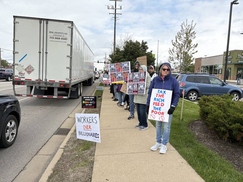Protestors hold up signs during a May 1 protest in McHenry Friday May 1, 2026.