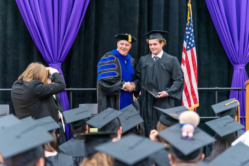 McHenry County College President Clint Gabbard shakes hands with a proud graduate at the winer commencement on Dec. 14, 2024.