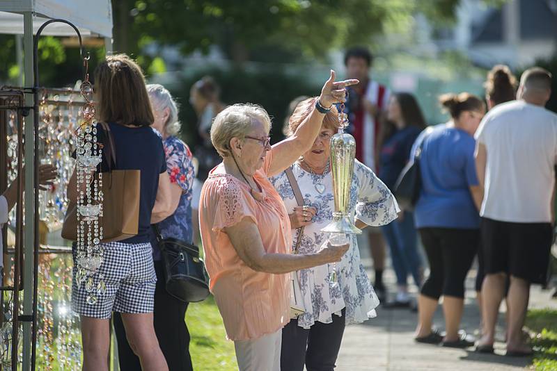 Kathy Hardesty holds up an ornate hummingbird feeder she’s selling Saturday, July 2, 2022, at Nuts About Art in Dixon.