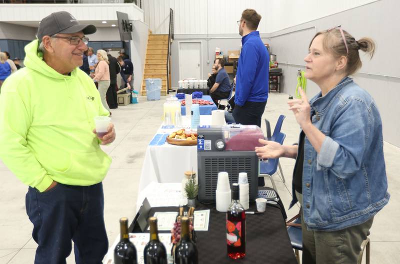Louis Budnick talks to Heidi Heerdt of Vintage Vines Wine Bar during the Illinois Valley Chamber of Commerce annual block party on Wednesday, April 29, 2029 at the Illinois Valley Regional Airport in Peru.