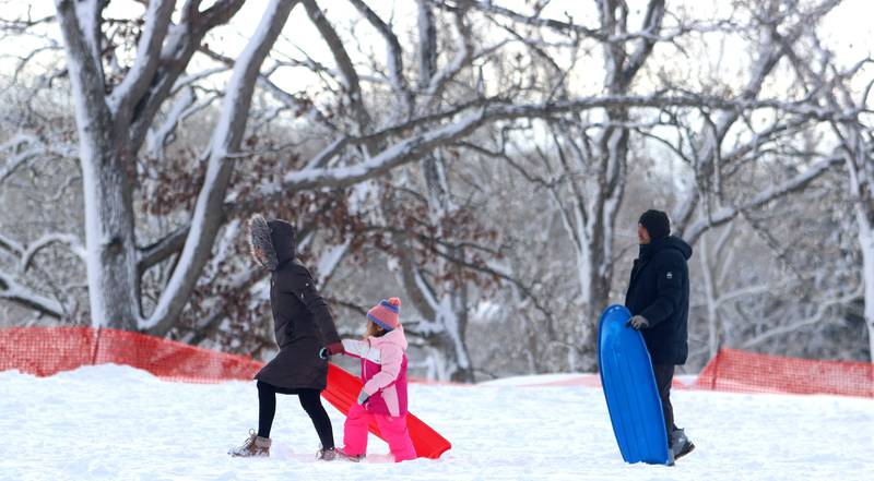 Sledders march toward the hill at Emricson Park in Woodstock Saturday in the wake of overnight snow.
