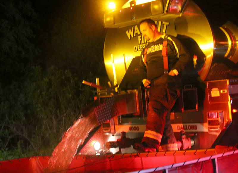 A Walnut firefighter fills a drop tank with a tender truck to fight a barn fire located in the 19000 block of 1725 East Street on Thursday, May 9, 2024 near Princeton. A box alarm was sent out shortly after 9:30p.m. for Bureau County fire units.