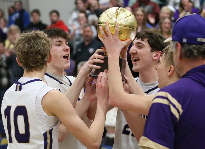 Members of the Serena boys basketball team hoist the Little Ten Conference Championship trophy after defeating Earlville on Friday, Feb. 2, 2024 at Somonauk High School.