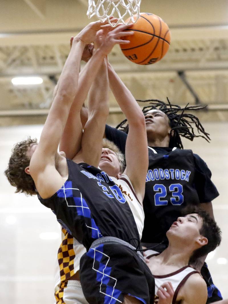 Richmond-Burton's Luke Robinson is sandwich between Woodstock’s Ty Steponitis (left) and Marc Thomas (right) as the battle for a rebound with Richmond-Burton's Dane Gardner during a Kishwaukee River Conference boys basketball game on Friay Jan. 9  2026, at Richmond-Burton High School, in Richmond.