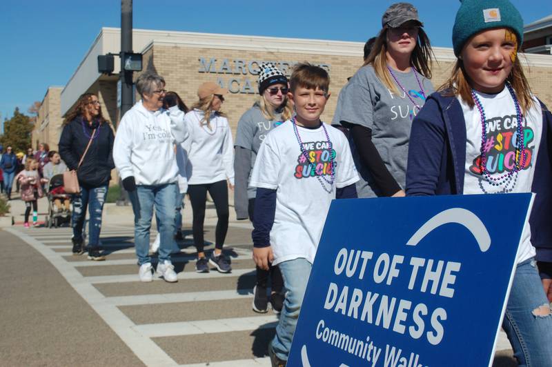 Participants in the Out of the Darkness Community Walk on Saturday, Oct. 15, 2022, cross Washington Street in downtown Ottawa. The annual event raises awareness and funds for suicide prevention.