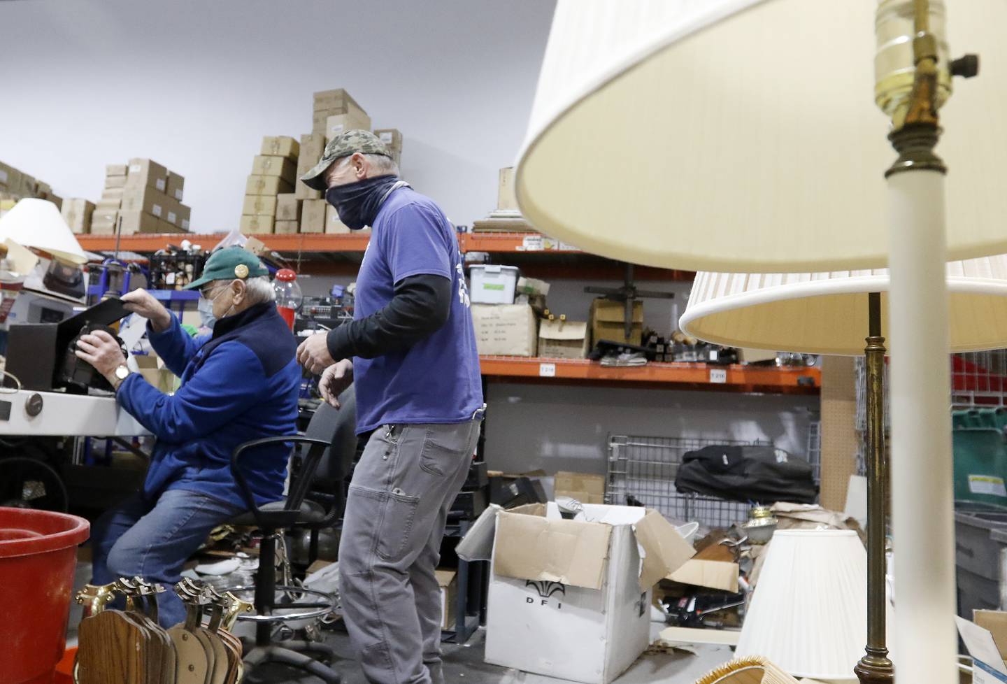 Warren Wascher, left, and Joe Dziedzic work in the back room rewiring and fixing electrical items Thursday, Nov. 18, 2021, at the Habitat for Humanity ReStore location in Woodstock.  A backlog of supplies at many retail furniture and home decor stores has contributed to an increase in shoppers purchasing their home furnishings from antique, thrift, and secondhand stores.