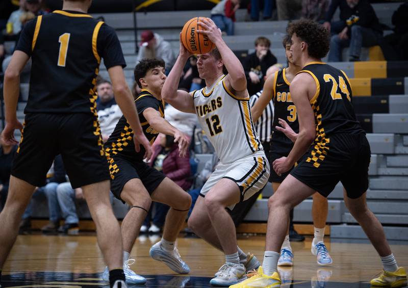 Herscher's Gavin Hull, center, is pressured by Reed-Custer's Chase Isaac, left, and Colton Waldvogel, right, in a game on Wednesday, November 26, 2025.