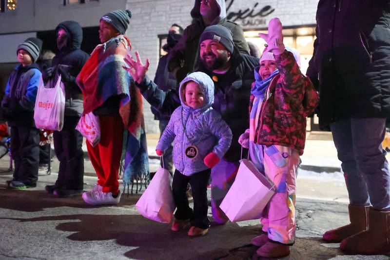 Dustin Kooy waves to Santa Claus with daughters Miya, 3, right, and Leighton, 2, all of Kankakee, during the 40th annual Bradley Christmas Parade on Friday, Dec. 5, 2025.