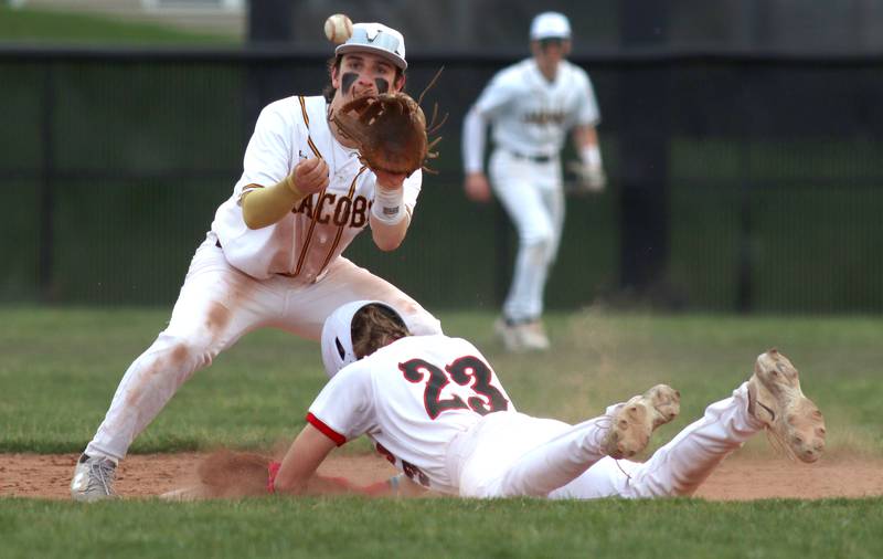 Huntley’s Kyle Larson, right, arrives safely at second base with a steal as Jacobs’ Gage Martin fields the toss in varsity baseball Wednesday at Huntley.