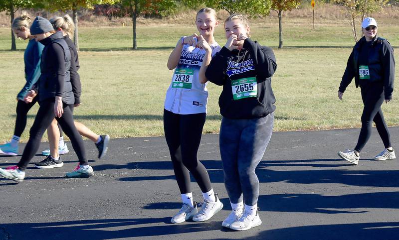 Lillyan Crawford and Brooke Wills make hand hearts as they begin the Sugar Grove Park District’s inaugural Run to Remember 5K & Fun Run on Saturday, Oct. 19, 2024 in Sugar Grove.