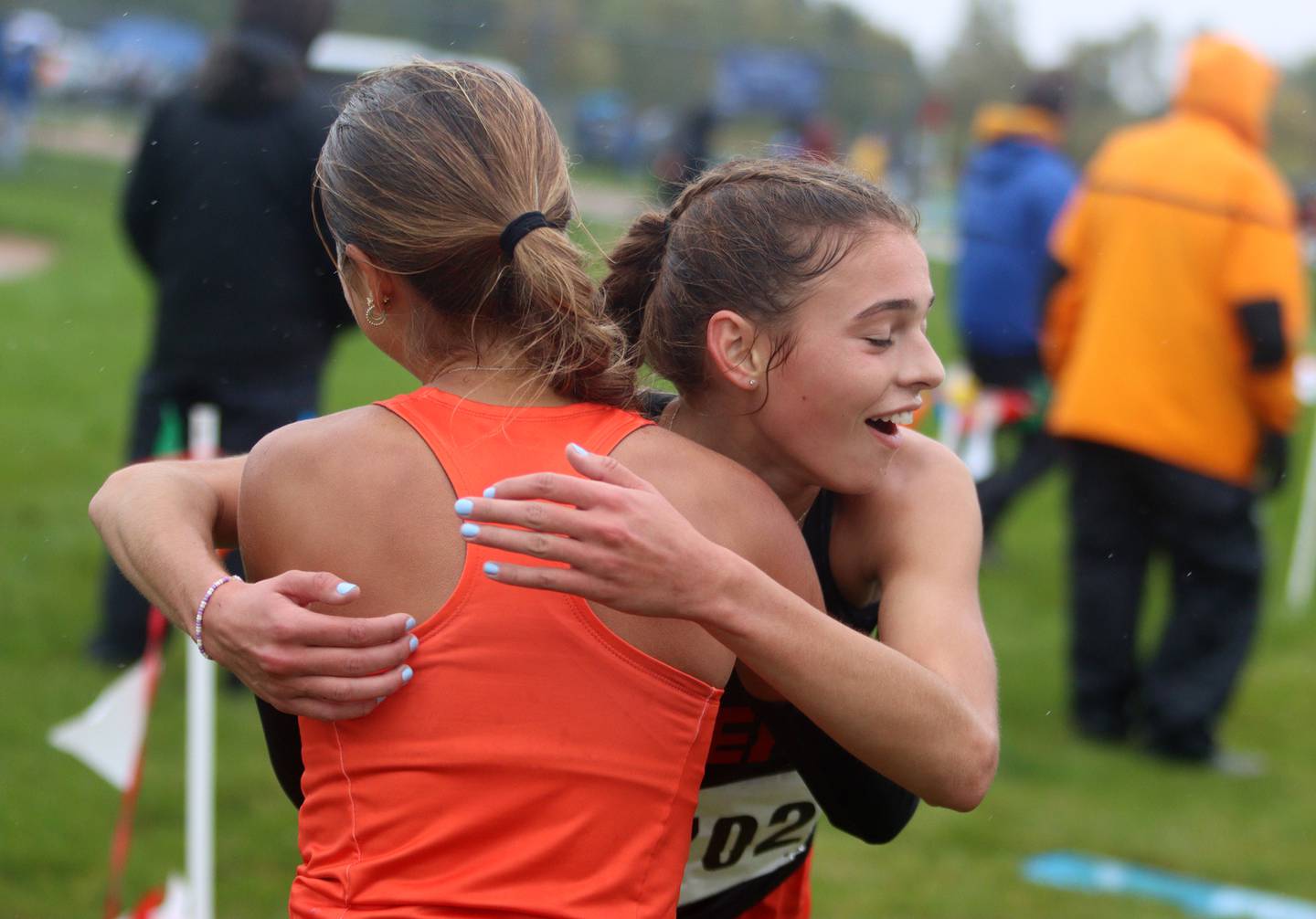 Hadley Ferrero of Crystal Lake Central is embraced by Danielle Jensen of McHenry after the finish of the Fox Valley Conference Girls Cross Country Meet at Plato Park in Elgin Saturday.