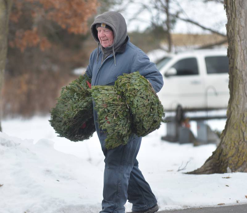 Veteran Dan Reimer carries wreaths at the Daysville Cemetery to be placed on veteran graves during the Wreaths Across America program on Saturday, Dec. 13, 2025.