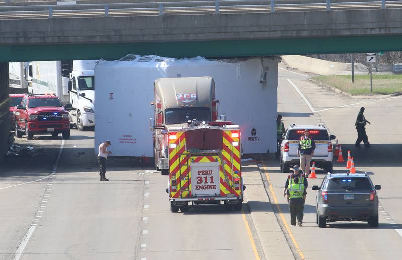 Peru firefighters work the scene of a semi truck that struck the U.S. Route 6 overpass on Monday, March 30, 2026 in Peru. Traffic was closed in both northbound and southbound directions on Illinios Route 251. Peru Police and Fire were on the scene. The incident happened shortly before 10a.m.