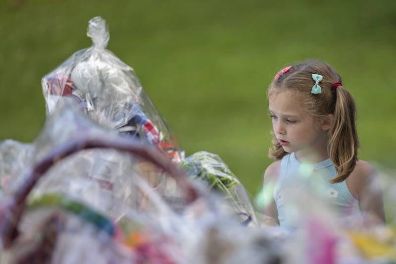 Briella Kemmerer, 5, looks over a table of raffle baskets being given away Friday, July 25, 2025, for the family fun day at the Emma Hubbs Tennis Classic in Dixon. The week-long Dixon tournament concluded with families playing tennis and sharing a meal.