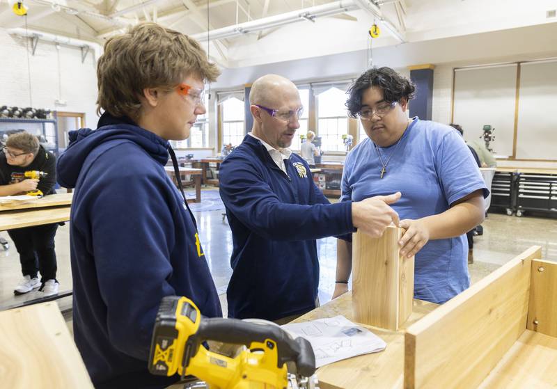 Joel Penne, instructor of the Technical Math class, helps students Noah Stephenson (left) and Derek Gaytan work on building a bluebird house Monday, Nov. 10, 2025.