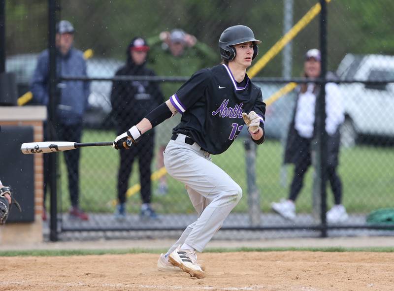 Downers Grove North's Jude Warwick (13) watches his hit during the varsity baseball game between Downers Grove South and Downers Grove North in Downers Grove on Saturday, April 29, 2023.
