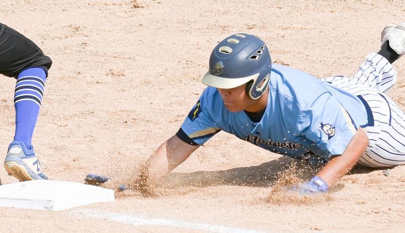 Marquette's Sam Mitre (32) dives safe to first during a pick-off play against Newman Monday at the supersectional.