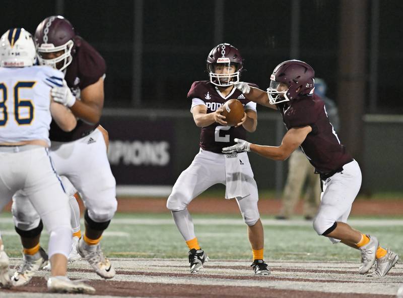 Lockport's Conley Pfeiffer hands the ball off to Johnny Wesolowski during a non-conference game against Wheaton North on Friday, Sep 06, 2024 at Lockport. (Dean Reid for Shaw Local News Network)
