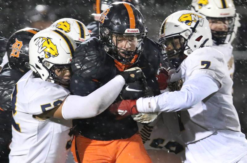 Neuqua Valley's Adam Filburn (left) and Miles Miskel wrap up DeKalb's Talen Tate during their game Friday, Oct.14, 2022, at DeKalb High School.
