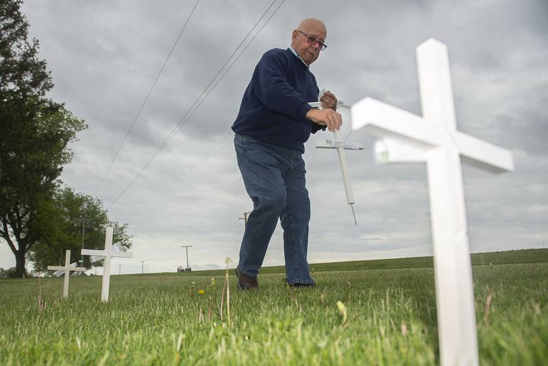 The Rev. Jim Miller of East Jordan Methodist Church sets out crosses Wednesday, May 25, 2022, outside of the rural Sterling church. The crosses were built to recognize the war in Ukraine and are free to anyone.
