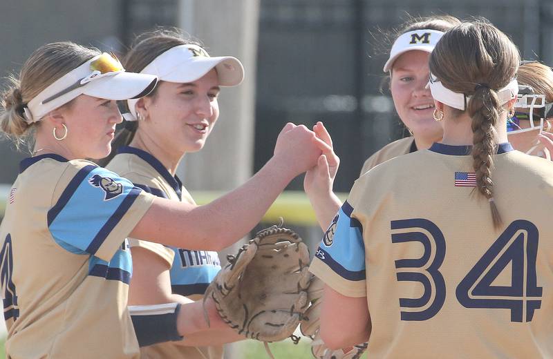 Marquette players fist bump between innings while playing Putnam County on Tuesday, April 29, 2025 in Ottawa.