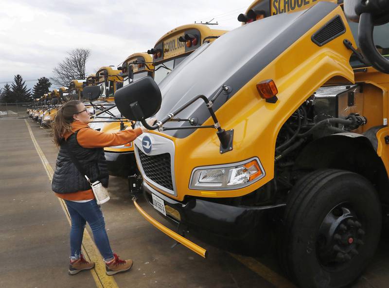 Bus driver and driver trainer Kim Wolff closes the hood on one of Johnsburg School District 12's new school buses Wednesday, Feb. 16, 2022, after doing a safety check before starting on her route. Before Johnsburg School District 12 stabilized its finances, the district could not afford to lease a brand-new fleet of school buses. These buses, which are 2022 models, were ordered over the summer and arrived in August. Getting to lease new meant that the district had more control of what direction it wanted to go, Director of Operations Tom Schwarz said, and so it decided to go with gasoline over diesel, which he said is better in terms of reliability and maintenance. That's one way the initial outlay may actually save the district money in the long term, he said. The district was also able to afford a longer five-year lease, which has a lower per-year cost. He said the district has also seen fewer behavioral issues with students vandalizing the buses now that they're nice and new.