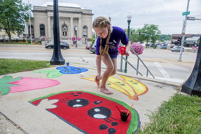 Olivia Moe, 8, of Dixon adds a spot of color on her piece depicting a quad of happy fruits Friday, July 1, 2022 during the Petunia Fest’s Brush and Bloom event at the old Lee County Courthouse. When pressed what her own favorite snack was, the young artist was quick to reply “watermelon.”