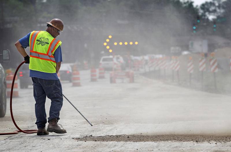 Scott Erickson of Plote blasts construction dirt and debris away from the road along Route 14 near the intersection of West Terra Cotta Avenue June 9, 2015, in Crystal Lake.