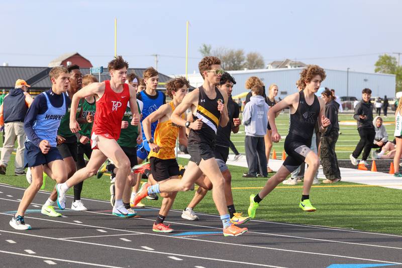 Herscher's Jeremy Szepelak, center, takes off with the pack during the 3200-meter race at the Herscher Track Invite on Friday, May 1, 2026.