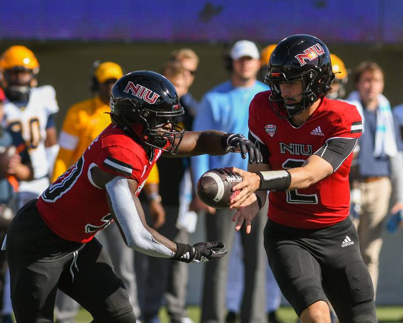 Northern Illinois QB Ethan Hamton (2) hands off to Harrison Waylee in the first quarter on Saturday Nov. 8th while taking on Toledo.