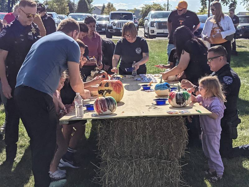 Families enjoy painting pumpkins during a joint safety campus open house between the Oswego Fire Protection District and the Oswego Police Department on Oct. 11, 2025.