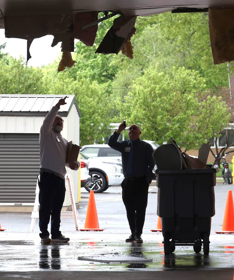 Northwestern Medicine Valley West Hospital employees inspect the damage in the ambulance bay after a truck too tall for the clearance tried to drive through it Tuesday, May 7, 2024, at the hospital in Sandwich. There was visible damage to the ceiling of the bay with insulation a wall material hanging down.