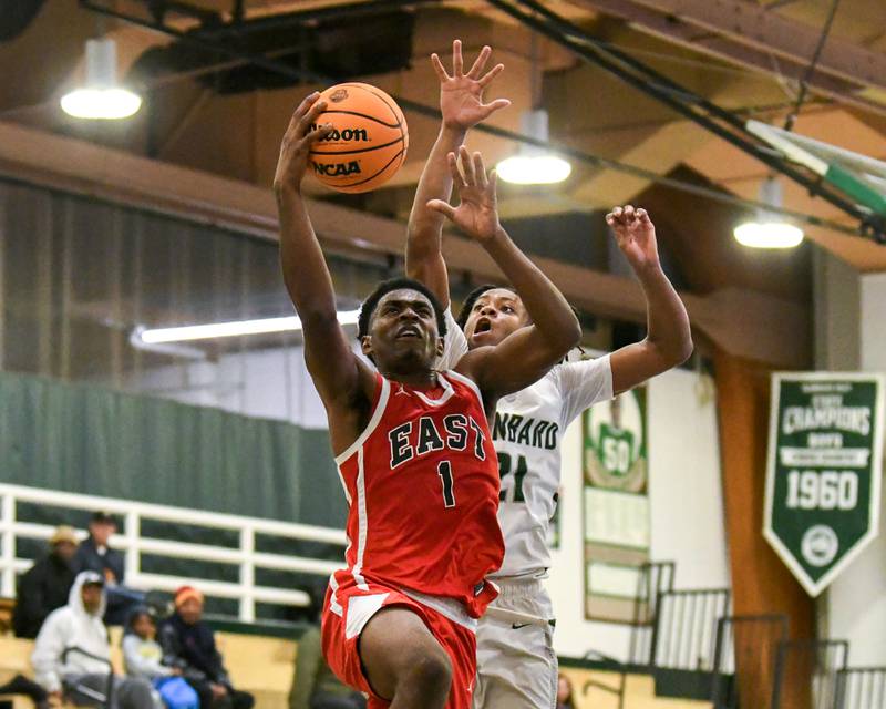 Glenbard East's Keenan House (1) goes up for a shot while being defended by Glenbard West's AJ Rayford (21) on Wednesday Nov. 26, 2025, during the District 87 Thanksgiving Invitational held at Glenbard West High School.