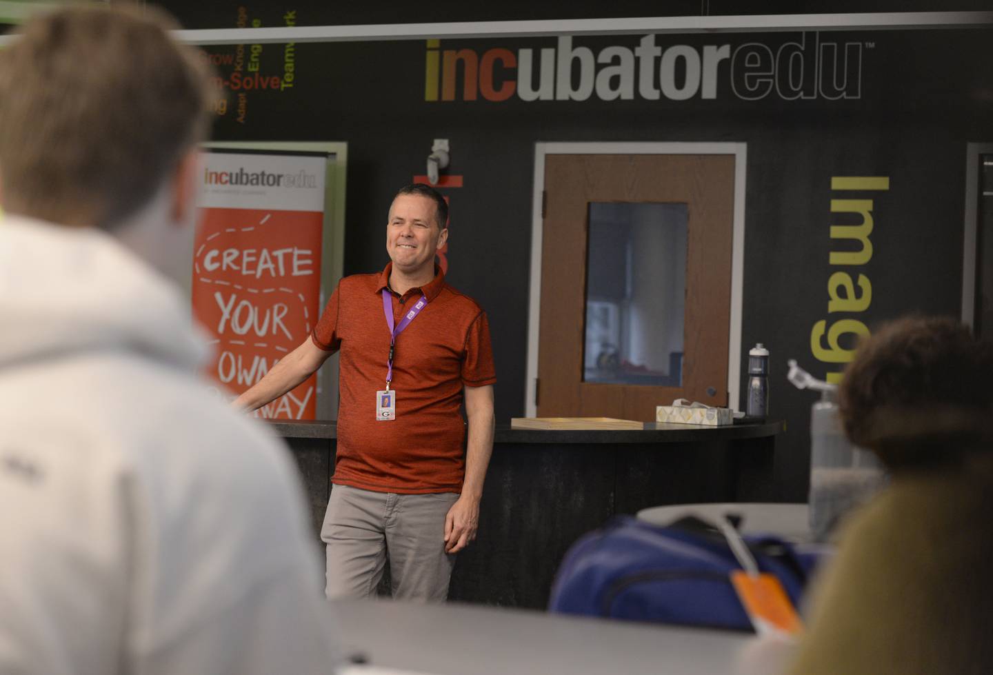 Glenbard East business teacher, Don Prochilo reviews student projects during class Thursday March 16, 2023.