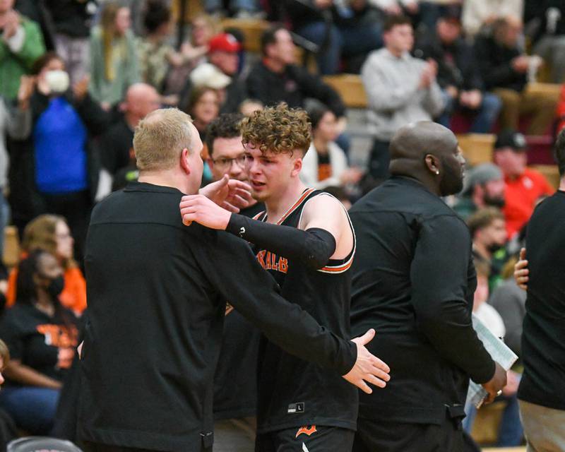 DeKalb Lane Mcvicar (23) gets a hug from DeKalb head coach Mike Reynolds as he walks off the court near the end of the game Friday March 4th as DeKalb loss to Larkin in the sectional final game Friday March 4th held at Huntley High School.