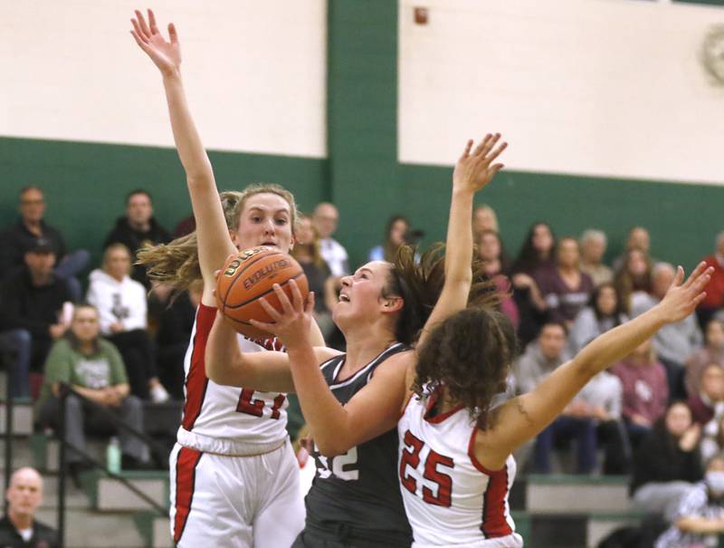 Prairie Ridge's Kelly Gende, center, drives tot he basket against Deerfield’s Olivia Kerndt, left and Lexi Kerstein, right,  during a IHSA Class 3A Grayslake Central Sectional semifinal basketball game Tuesday evening, Feb. 22, 2022, between Prairie Ridge and Deerfield at Grayslake Central High School.