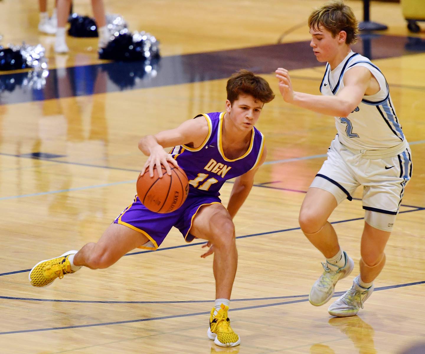 Downers Grove North's Owen Thulin (11) drives past Downers Grove South's Will Potter during a crosstown game on Dec. 17, 2022 at Downers Grove South High School in Downers Grove .