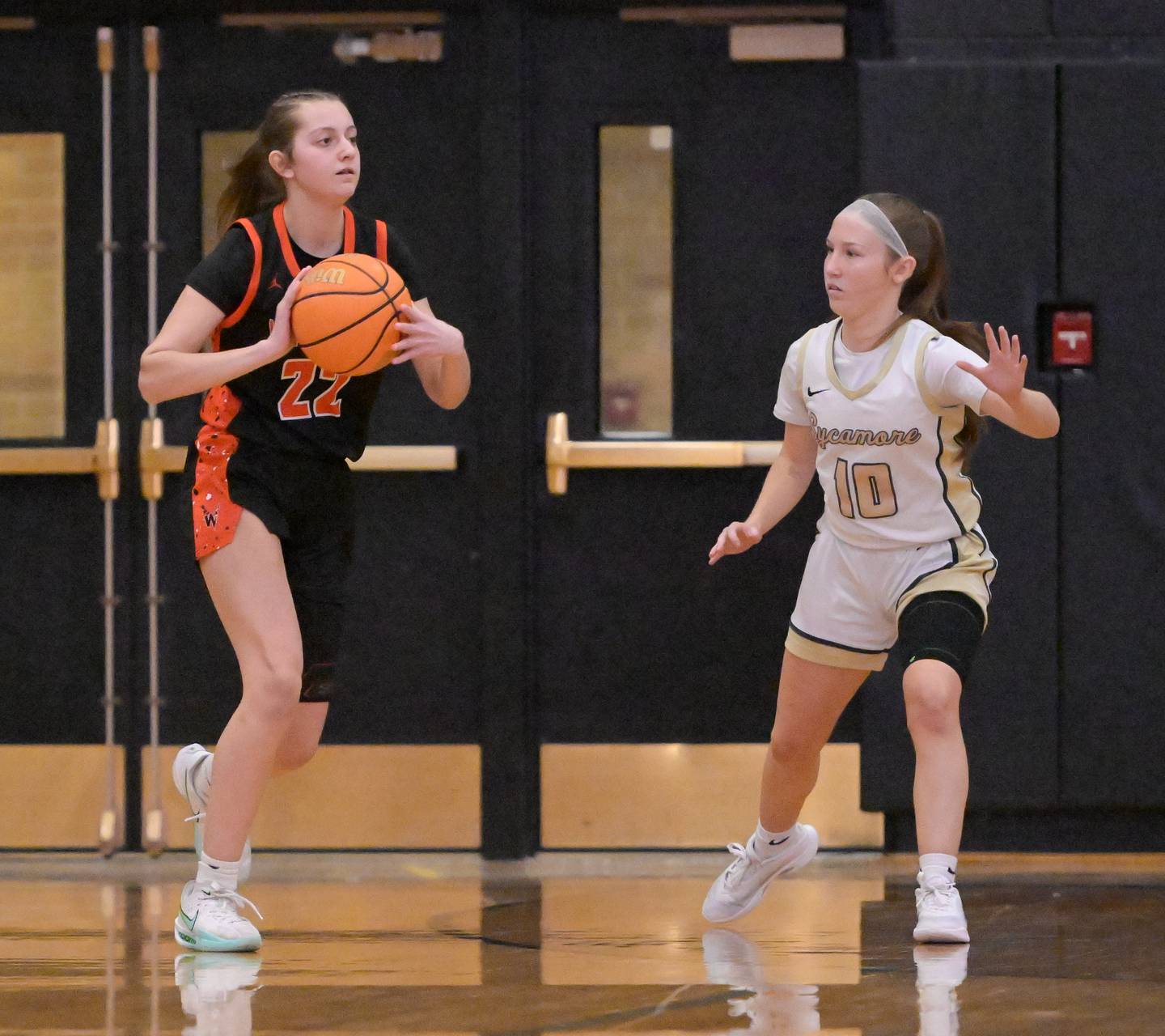 Winnebago's Alyssa Zambrovitz (22) passes the ball around Sycamore's Cortni Kruizenga (10) during a game in Sycamore on Wednesday, Jan. 21, 2026.