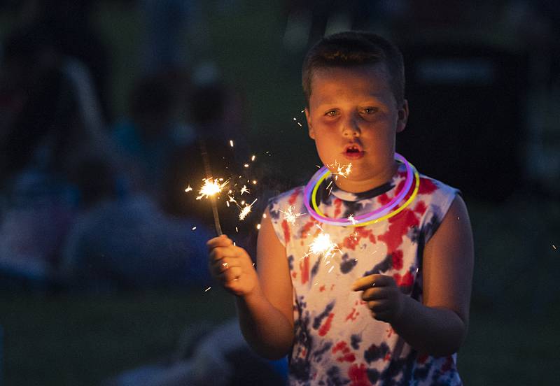 Connor Cardwell, 7, plays with sparklers Wednesday, July 3, 2024 while waiting for the fireworks show in Rock Falls.