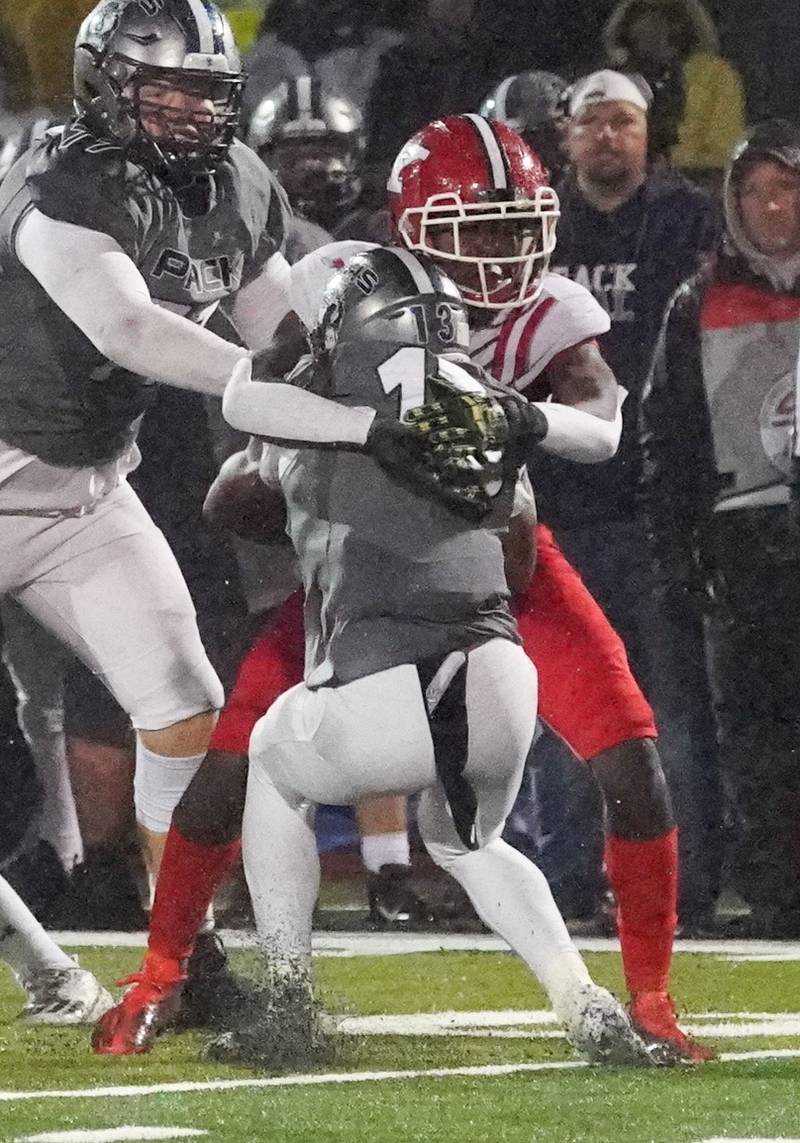 Yorkville's Bryce Griffin (28) hits Oswego East's Jasiah Watson (13) in the backfield for a loss during a football game at Yorkville High School on Friday, Oct. 13, 2023.