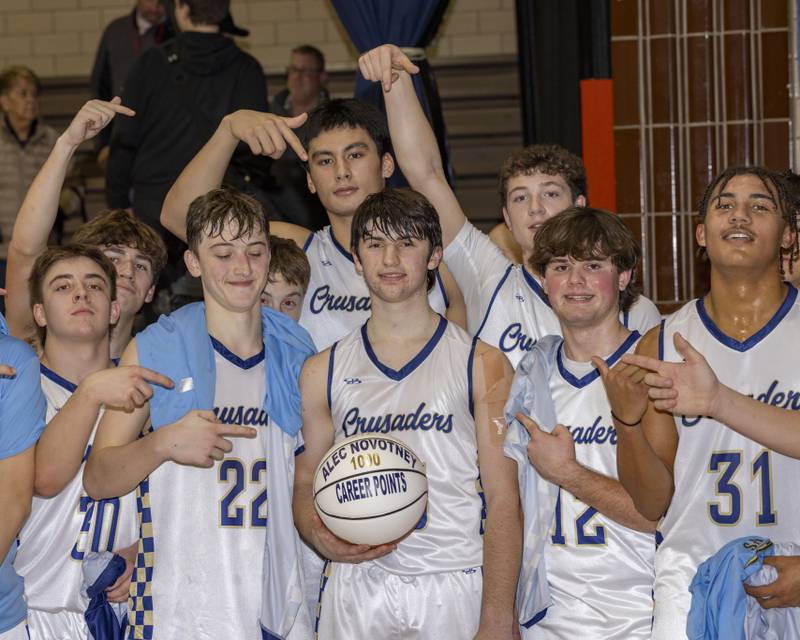 Alec Novotney celebrates with teammates after scoring his 1000th point during the game against Henry-Senachwine on February 7, 2025 at Bader Gym.