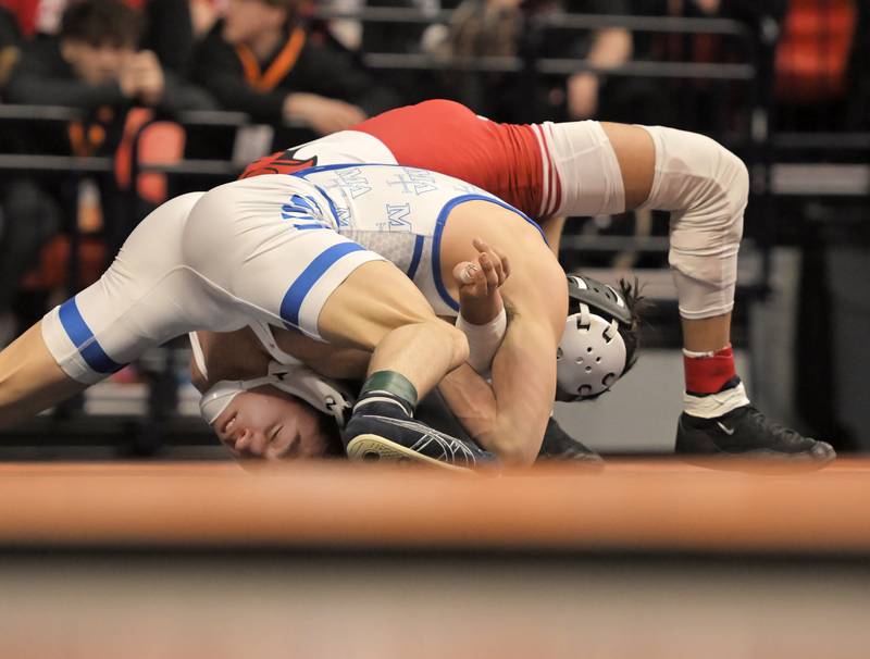Marmion Academy’s Nicholas Garcia, top, controls Michael Esteban of Marist in the Class 3A 126-pound final at the IHSA boys state wrestling championships at the State Farm Center in Champaign on Saturday, Feb. 22, 2025.