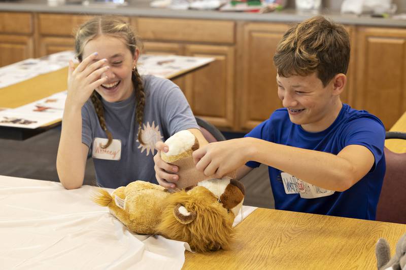 Workshop attendees Whitney and Wyatt have fun learning how to vet wrap on a stuffed animal Monday, July 28, 2025.